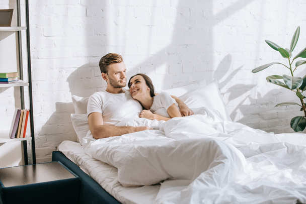 happy young couple relaxing in bed in morning - Fotoğraf, Görsel