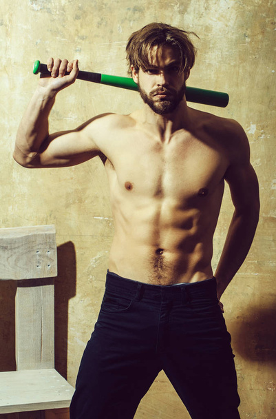 Bearded macho standing with green baseball bat - Foto, afbeelding