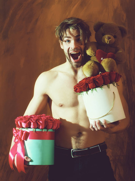 bearded muscular man with sexy body holds red rose box - Fotoğraf, Görsel