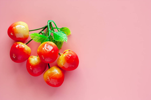 Simulaatio fake ja keinotekoinen hedelmiä vaaleanpunainen tausta koristeet
 - Valokuva, kuva