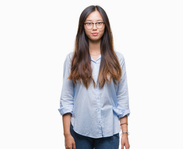 Young asian business woman wearing glasses over isolated background with serious expression on face. Simple and natural looking at the camera. - Φωτογραφία, εικόνα