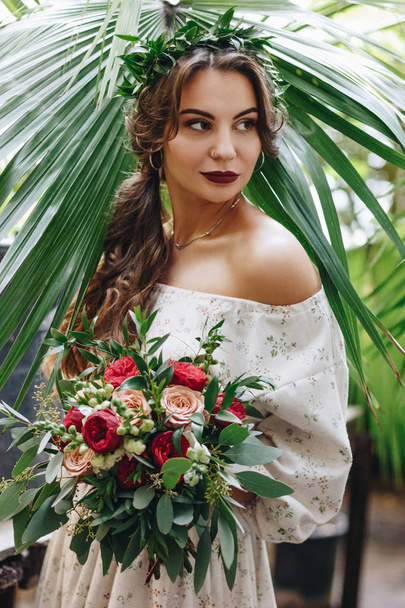 Beautiful bride with bouquet in botanical garden - Foto, imagen
