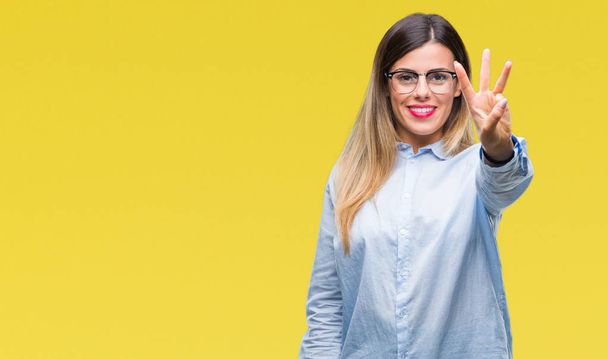 Young beautiful business woman wearing glasses over isolated background showing and pointing up with fingers number three while smiling confident and happy. - Photo, Image