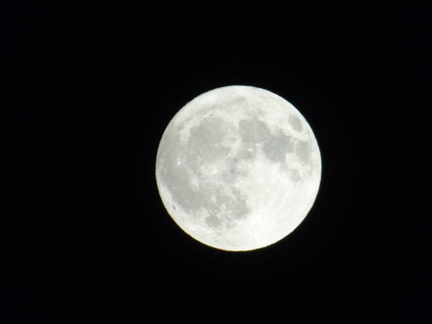 Una straordinaria fotografia della luna piena sotto un cielo buio con alcune piccole stelle sullo sfondo
 - Foto, immagini
