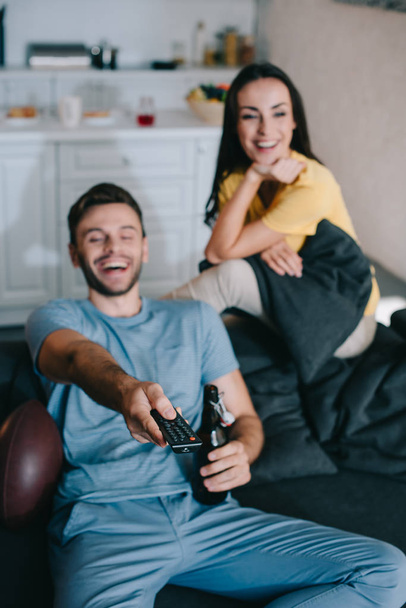 happy young couple watching american football game at home - Fotografie, Obrázek
