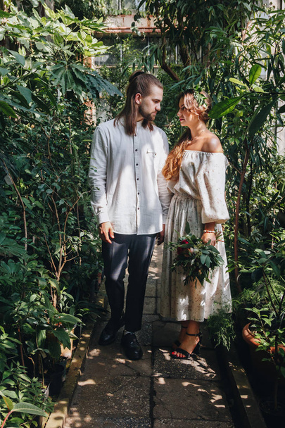 Beautiful wedding couple walking in botanical garden - Photo, Image