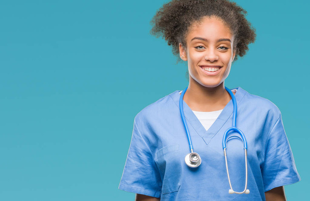 若いアフロ ・ アメリカ人医師女性の顔に幸せとクールな笑顔で孤立した背景の上。幸運な人. - 写真・画像