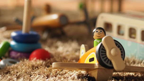 Beaucoup de jouets en bois colorés pour bébés sur un tapis de couleur brun clair qui incluent la balle, l'avion, le bus et d'autres qui aident à développer l'égalisation et le QI du bébé et font passer des moments de joie à bébé
. - Photo, image