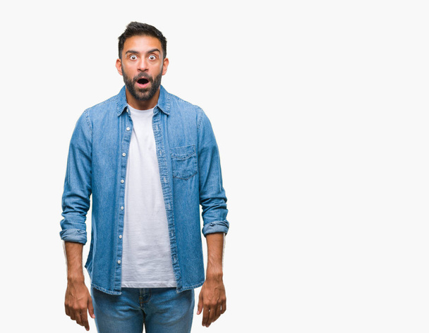 Adult hispanic man over isolated background afraid and shocked with surprise expression, fear and excited face. - Photo, Image