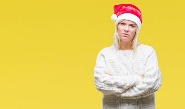 Νέοι όμορφη ξανθιά γυναίκα που φοράει καπέλο Χριστουγέννων πάνω από απομονωμένες φόντο σκεπτικιστής και νευρικό, αποδοκιμασίας έκφραση προσώπου με σταυρωμένα τα χέρια. Αρνητικό πρόσωπο. - Φωτογραφία, εικόνα
