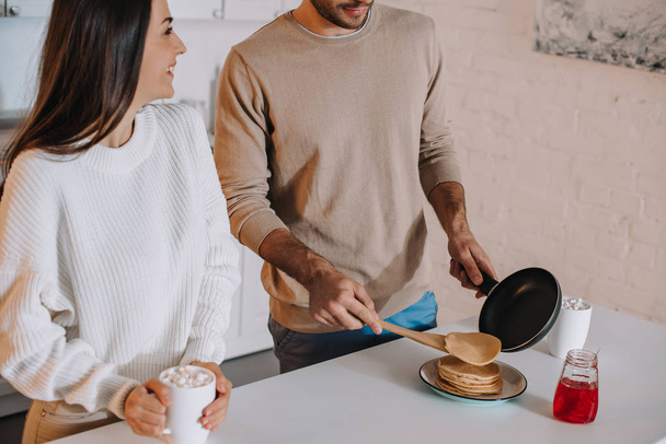 cropped shot of young couple making pancakes for breakfast together at home - Photo, Image