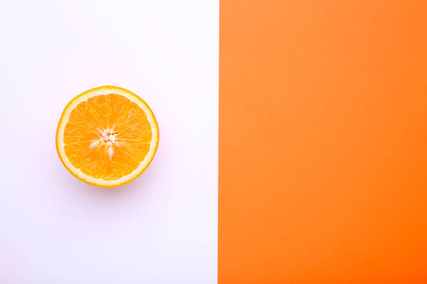 Half of ripe orange fruit on a colorful background - Photo, image