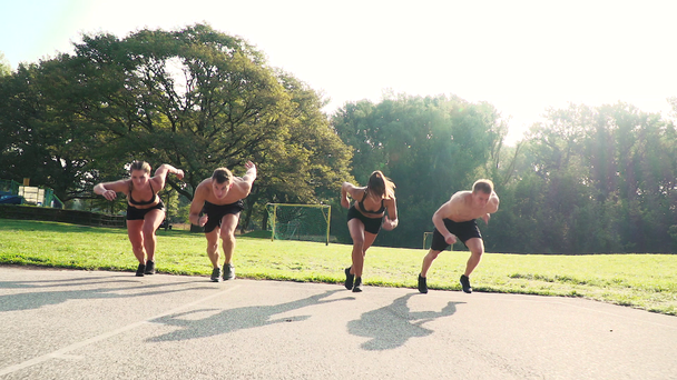 naiset, joilla kaksi miestä tekee lyhyen sprintin stadionilla
 - Materiaali, video