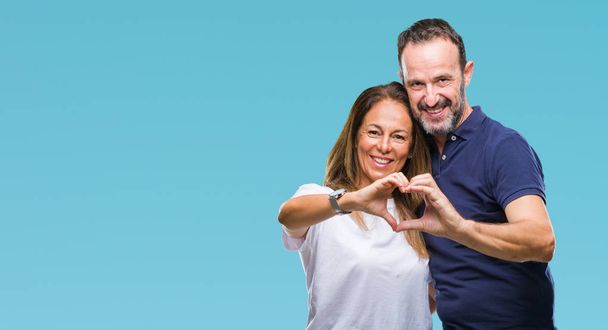 Middle age hispanic casual couple over isolated background smiling in love showing heart symbol and shape with hands. Romantic concept. - Foto, Bild