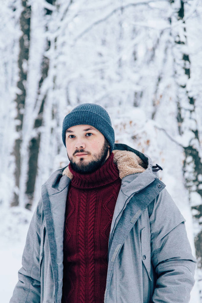 a man in a gray down jacket in a snowy field - 写真・画像