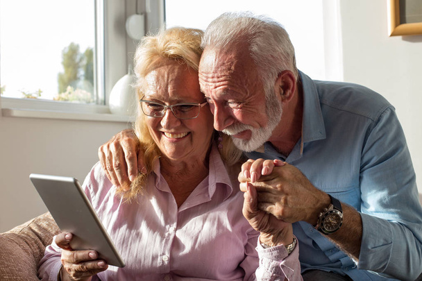 Пожилая пара, использующая планшет для общения с семьей
 - Фото, изображение