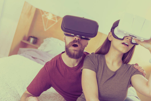 Nice couple playing video games in VR glasses - Φωτογραφία, εικόνα