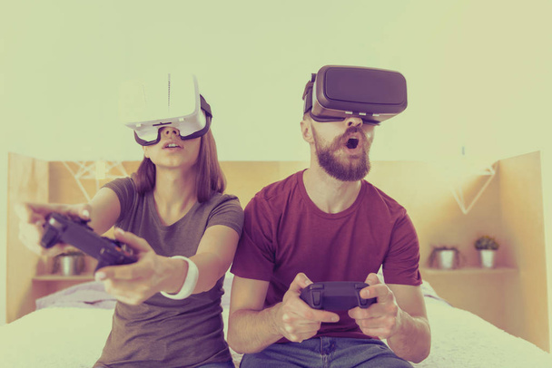 Young man and woman competing in VR glasses - Photo, image