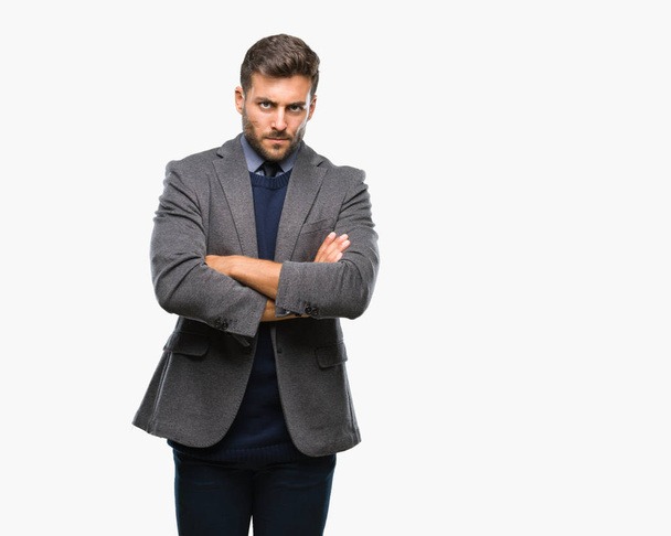 Young handsome business man over isolated background skeptic and nervous, disapproving expression on face with crossed arms. Negative person. - Foto, Bild