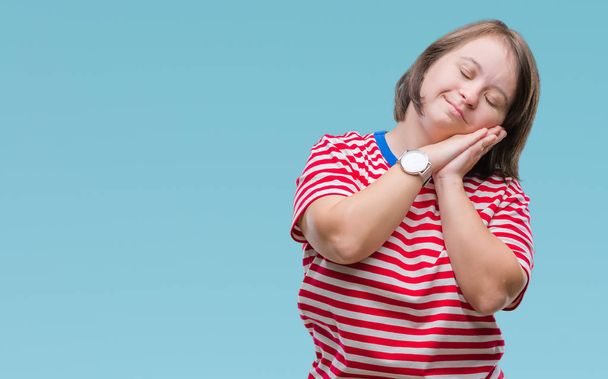 Młoda kobieta dorosłych z zespołem Downa na białym tle spania zmęczony marzy i pozowanie ręce razem jednocześnie uśmiechając się z zamkniętymi oczami. - Zdjęcie, obraz