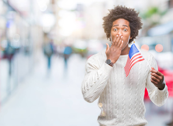 Afro-amerikai ember zászlaja Egyesült Államok feletti elszigetelt háttér terjed száj, kezével döbbenve, hiba, kifejezés, a félelem, szégyen ijedt csendben, titkos koncepció - Fotó, kép