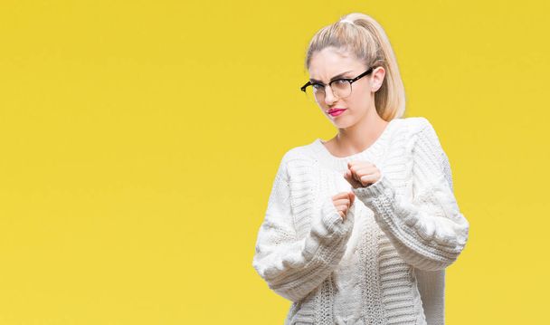 Young beautiful blonde woman wearing glasses over isolated background disgusted expression, displeased and fearful doing disgust face because aversion reaction. With hands raised. Annoying concept. - Photo, Image