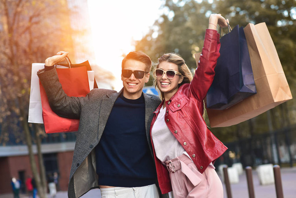 Portrait d'un couple avec des sacs à provisions dans la ville.Personnes, vente, amour et bonheur concept
. - Photo, image