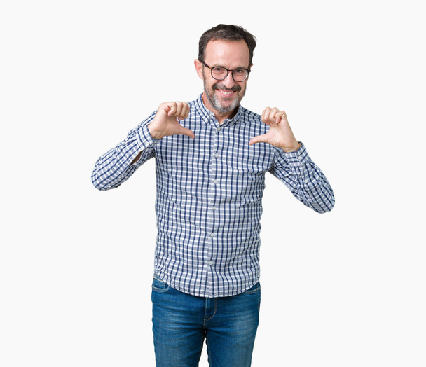 Handsome middle age elegant senior business man wearing glasses over isolated background looking confident with smile on face, pointing oneself with fingers proud and happy. - Photo, image
