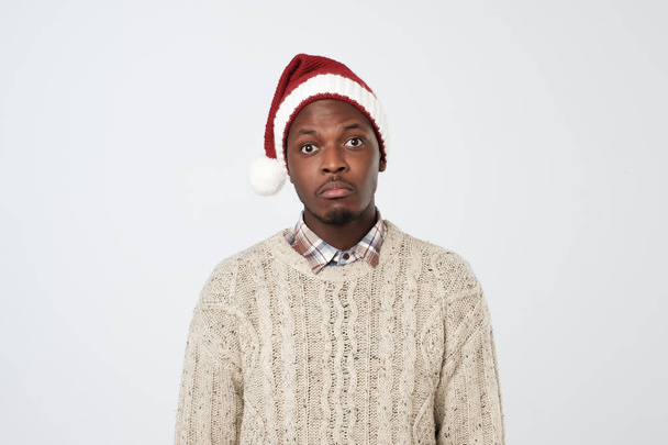Smutny i samotny dojrzały mężczyzna Afryki w Santa Claus kapelusz na białym tle - Zdjęcie, obraz