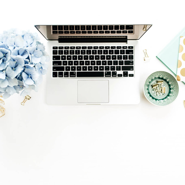 moderner Home-Office-Schreibtisch mit Laptop, Hortensienblütenstrauß, Accessoires auf weißem Hintergrund. flache Lage, Draufsicht. - Foto, Bild