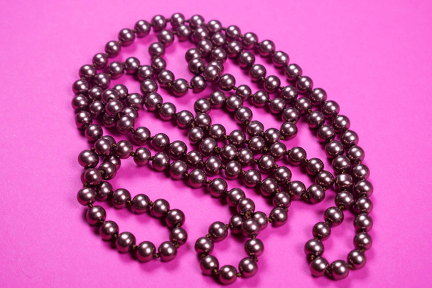Brown shiny necklace on a pink background, - Photo, Image