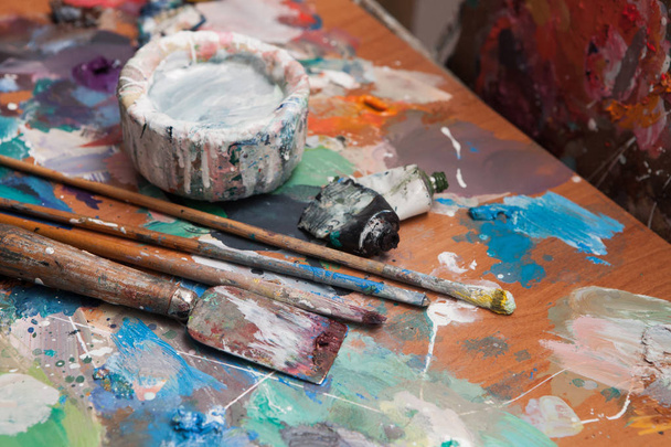 Oil paints and paint brushes on a palette - Fotó, kép