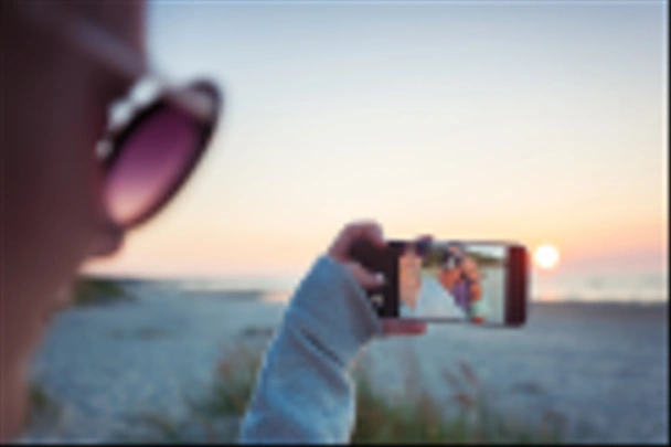 Mädchen machen Selfie vor spektakulärem Sonnenuntergang mit Handy  - Foto, Bild