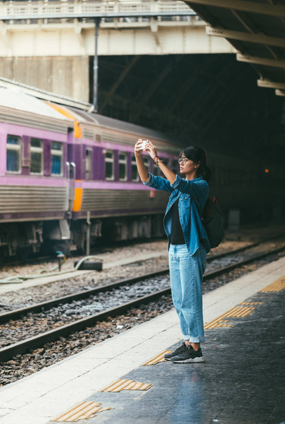 Asian woman traveler used smart phone take photos while wait and - Фото, изображение