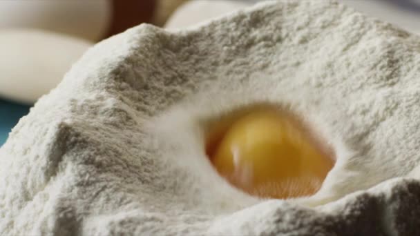 Zbliżenie: jajko w mące. Sceny. Koncepcja gotowania. Przygotowanie ciasta domowej roboty z białej mąki - Materiał filmowy, wideo