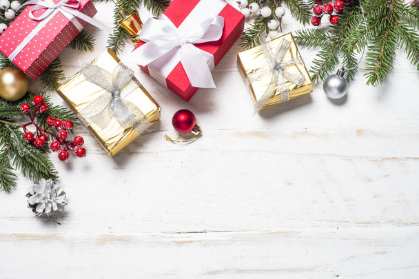 Scatola regalo in rosso e oro e decorazioni su fondo in legno bianco
 - Foto, immagini