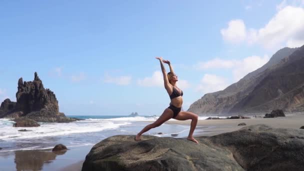 Sportowy kobieta medytuje i rozciąga się jej mięśni po treningu jogi i równowagi z naturą. Wyspy Kanaryjskie Teneryfa - Materiał filmowy, wideo