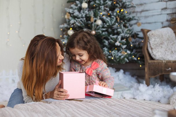 Feliz mamá con niño mirando dentro de la caja mágica de regalo de Navidad
 - Foto, Imagen