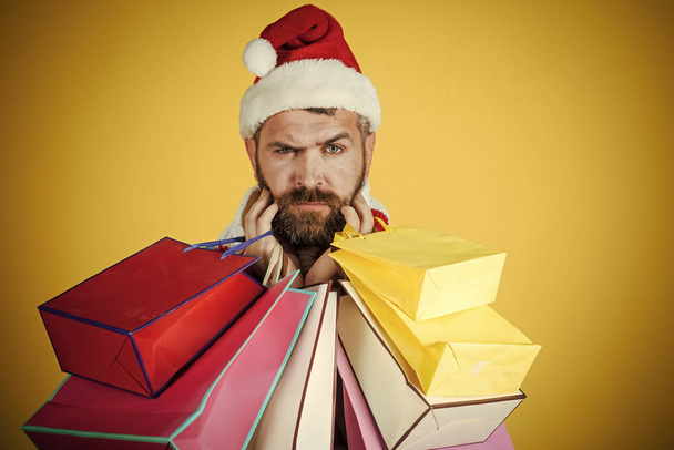 Christmas man hold shopping bags on yellow background - Fotó, kép