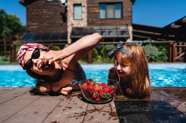 Two little girls on the side of the pool - Photo, Image