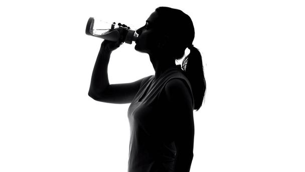 Sportswoman drinking beverage, keeping water balance after workout, healthcare - Zdjęcie, obraz
