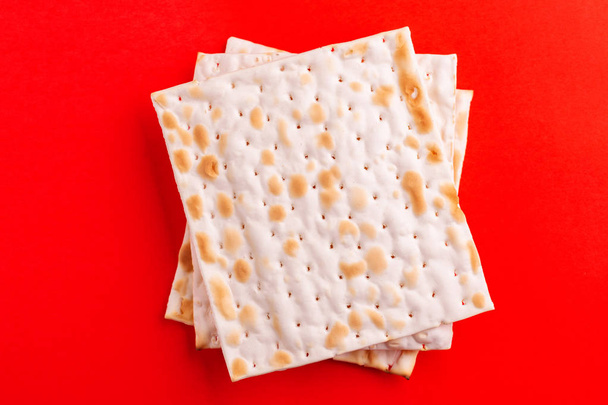 Traditional Jewish kosher matzo on bright red background. Copy space. Top view - Foto, imagen