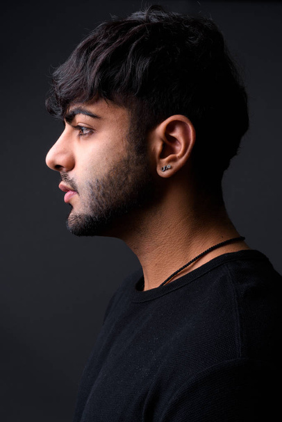 Fiatal jóképű indiai férfi szürke háttér - Fotó, kép