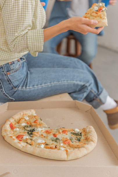 cropped shot of woman holding tasty pizza at new home - Foto, afbeelding
