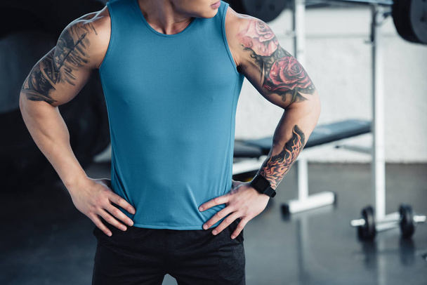 cropped view of young tattooed sportsman at gym  - Photo, Image