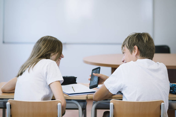 Couple young students with smartphone at school - Фото, зображення