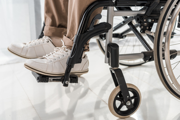 close up on male legs in wheelchair in nursing home - Фото, зображення