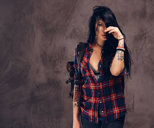 Seductive tattooed hipster girl posing in a studio. - Photo, Image