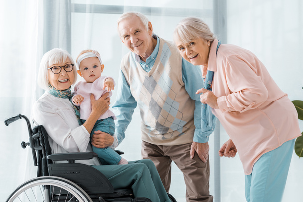 happy senior people with toddler in nursing home - Foto, immagini