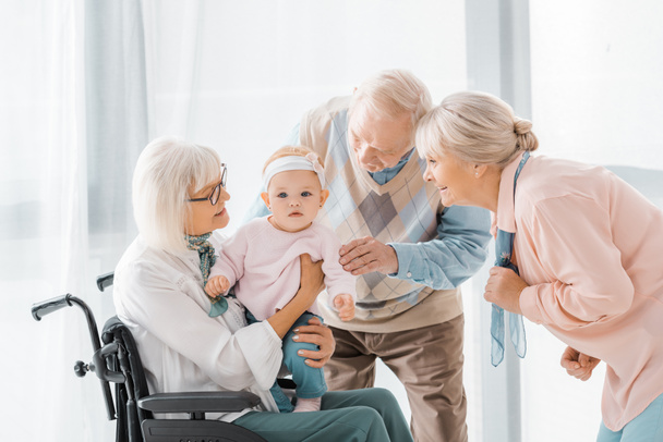 happy senior people playing with toddler in nursing home - Photo, Image